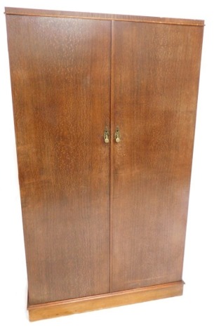 An oak compactum wardrobe, The Verithing, with two doors enclosing a mahogany lined fitted interior with ivorine labelled drawers and shelves, 186cm high, 108cm wide.