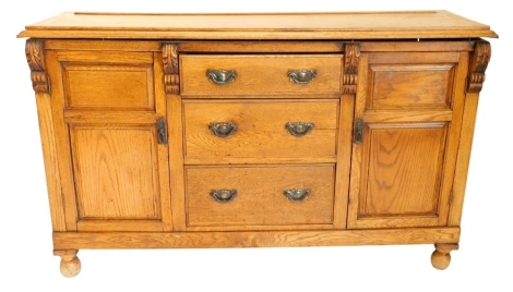 A 19thC oak dresser base, the top with a moulded edge above three drawers, flanked by double panelled doors on bun feet, 149cm wide.