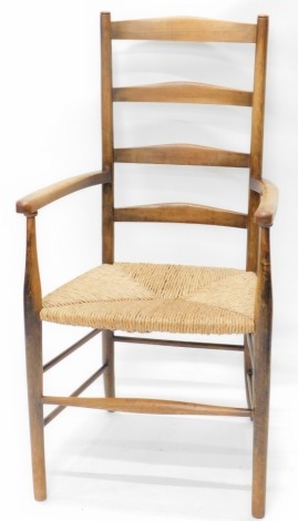 A late 19th/early 20thC beech Arts & Crafts style ladder back chair, with a rush seat, on turned legs.