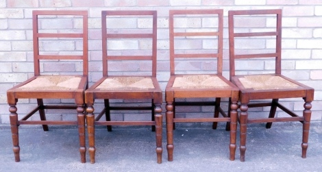 A set of four late 19th/early 20thC mahogany ladder back dining chairs, each with a rush seat on turned legs.