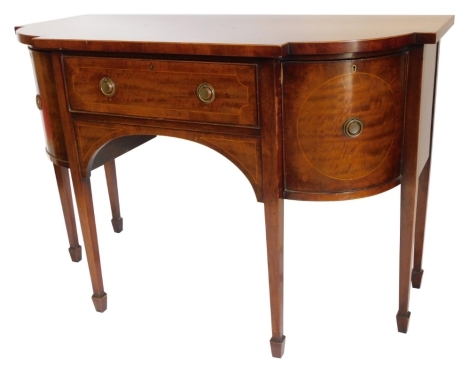 A mahogany sideboard in George III style, the shaped top with a crossbanded border above a frieze drawer flanked by two curved doors, each with circular brass drop handles, on square tapering legs with spade feet, 92cm high, 136cm wide.