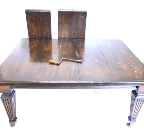 A late 19th/early 20thC oak extending dining table, the rectangular top with canted corners, on square tapering reeded legs with castors, two loose leaves, 75cm high, 120cm wide, 149cm long extended.