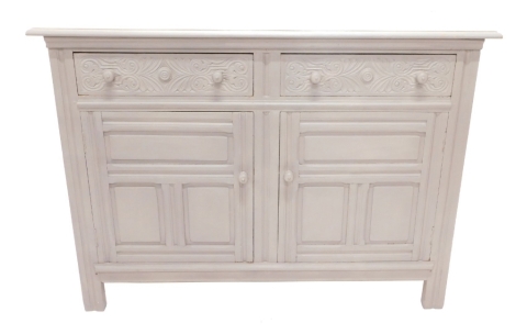 A grey painted oak sideboard, the top with a moulded edge above two carved frieze drawers and two panelled doors on stiles, 133cm wide.