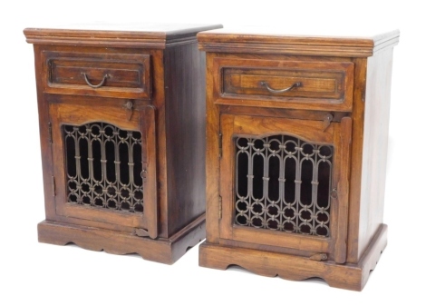 A pair of continental hardwood side cabinets, each with a frieze drawer and door with metal grill, on bracket feet, 50cm wide.