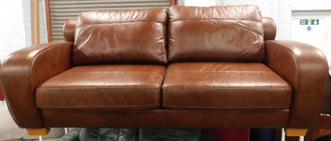 A brown leather sofa with curved arms and back, on oak square tapering feet. 205cm wide