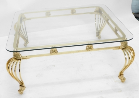 A modern brass and glass coffee table, the square top with rounded corners, the base cast with shelves and with cabriole shaped legs. 45 high x 107 wide