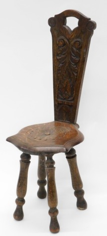 An early 20thC carved oak spinning chair, with a solid seat on turned legs.