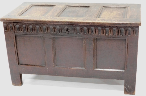 A late 17thC oak coffer, with three panelled lid, with a carved frieze on stiles. 106cm wide