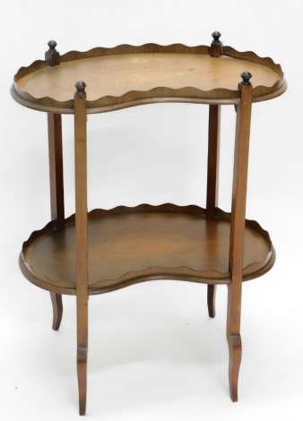 An Edwardian mahogany kidney shaped two tier whatnot, each tier with a raised gallery and inlaid centrally with a shell, on splayed legs, 75cm high, 58cm wide.