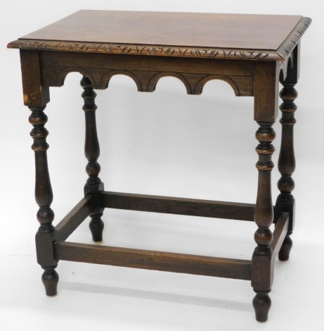 An oak rectangular occasional table, with a carved border on turned supports and feet, 66cm wide.