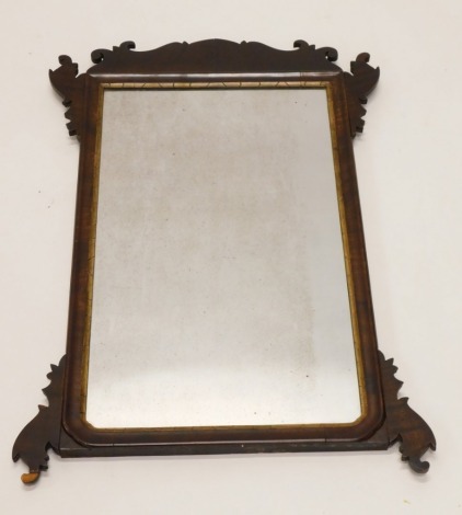 A mahogany fret framed wall mirror, the rectangular plate with a parcel gilt slip, surrounded by shaped corners, 79cm high, 53cm wide.