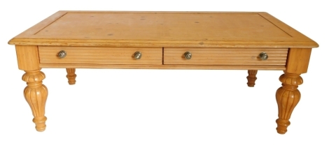 A pine coffee table, the rectangular top with a moulded edge above two frieze drawers, on fluted turned bulbous legs, 47cm high, 132cm wide.