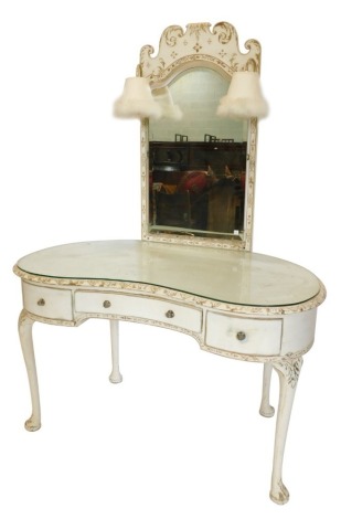 A cream painted kidney shaped dressing table, the raised back with a rectangular mirror plate, with ornate framing, the base with a glass top above three drawers on cabriole legs, 115cm wide.