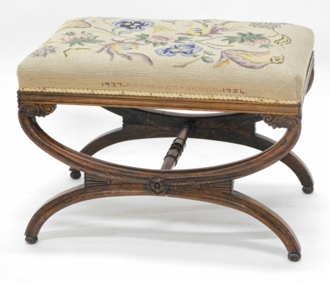 A Victorian rosewood stool, with a woolwork padded seat on X shaped supports, 64cm wide.