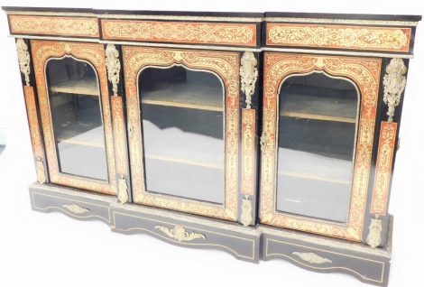 A mid to late 19thC ebonised and Boulle breakfront side cabinet, with gilt metal mounts, the frieze decorated with scrolls, leaves, etc., above three glazed doors, on a plinth, 110cm high, 183cm wide.