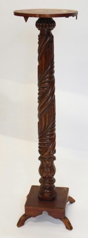 A mahogany torchere, with circular top and a carved turned column and square platform with splayed legs, 112cm high.