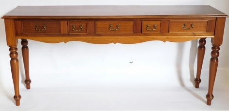 A mahogany serving table, the rectangular top with a moulded edge above five drawers and a shaped apron on turned tapering legs, 81cm high, 177cm wide, 47cm deep.