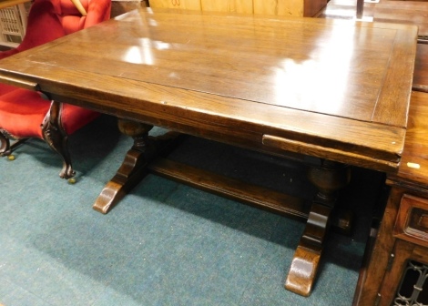 An oak draw leaf extending refectory table, with cup and cover supports and flat stretcher, 143cm wide.