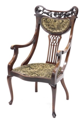 An Edwardian walnut open armchair, the shaped back with a pierced splat and leaf and scroll carved crest, with a padded back rest and seat, on cabriole legs.