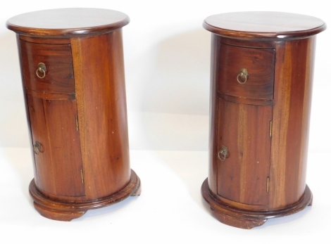 A pair of hardwood cylindrical pedestals or columns, each with a moulded edge, on tapering feet, 65cm high, 36cm diameter.