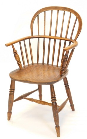 A 19thC ash and elm Windsor armchair, with a shaped back, spindle turned supports and a solid seat, on turned legs with H stretcher.