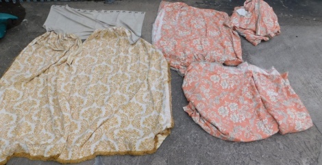 A pair of full length curtains, in patterned coral coloured fabric.