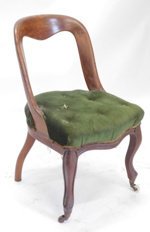 A Victorian mahogany spoon back chair, with a green upholstered padded seat on cabriole legs with castors.