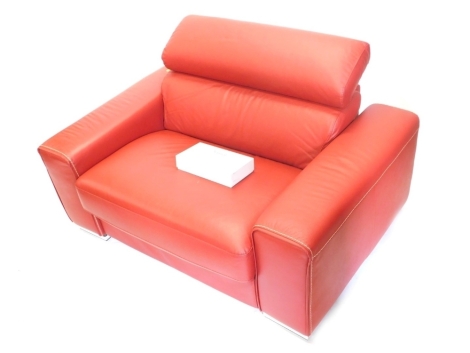 A red leather and chrome armchair or bed, with metal frame work.