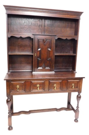 An oak dresser, the plate rack with a moulded cornice above two shelves, the base with two panelled drawers, on turned supports with stretcher and bun feet, 186cm high, 125cm wide.