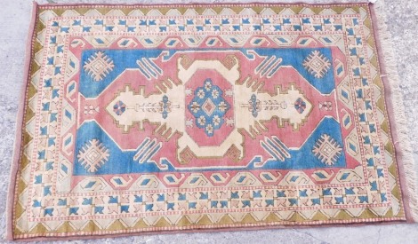 A Turkish rug, with a multicoloured geometric design with medallions, etc., on a cream ground with multiple borders, 206cm x 132cm.