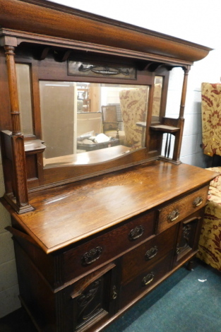 A late 19thC oak Art Nouveau mirror back sideboard, with canopy top inset with a copper panel, above a shaped glass flanked by further mirrors, the subsection set with two frieze drawers and two further drawers flanked by cupboards, on turned feet, 189cm 