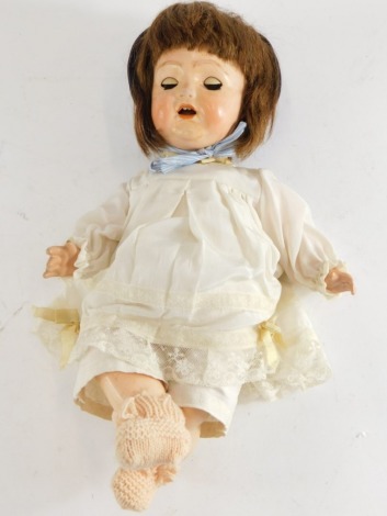 A German bisque headed porcelain doll, with sleep eyes and composition body, marks indistinct, 39cm long.