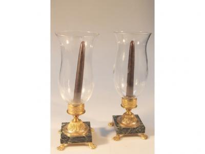 A pair of gilt and marble hurricane lamps with glass shades