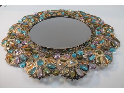 A large wall mirror with cast metal mounts and multi coloured facet cut