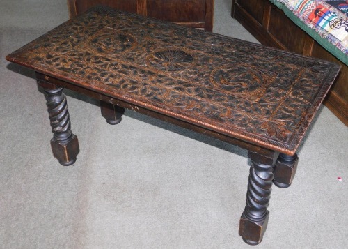 A 19thC and later carved oak occasional table, with rectangular top having stylised figures and Ho-ho bird, on adapted barley twist legs, 46cm high, 92cm wide, 48cm deep.