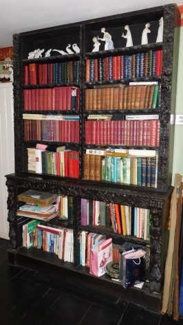 A Victorian carved oak open bookcase, with figures of child and Ho-ho bird to the uprights, and floral scrolls, and egg and dart mouldings to shelf fronts, 234cm high, 164cm wide, 40cm deep.