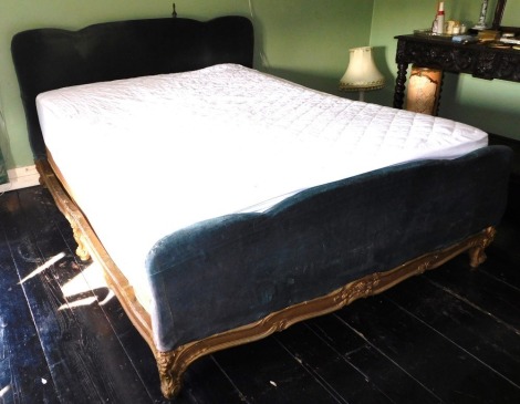 An early 19thC French giltwood double bed, with later velvet applied headboard and footboard.