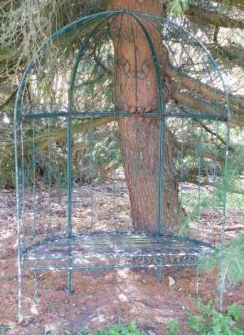 A curved metal garden seat, with arched canopy top, 123cm wide.