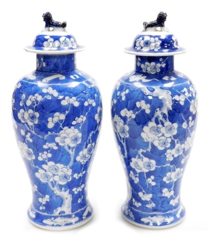 A pair of late 19thC Chinese porcelain baluster vases and covers, each decorated with flowering prunus trees, four character Kangxi mark to underside, 35cm high.