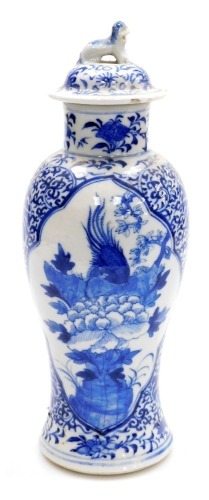 A 19thC Chinese porcelain baluster vase and cover, the lid with dog of fo finial, decorated in blue and white with reserves of a phoenix and a flowering branch, four character Kangxi mark to underside, 27cm high.