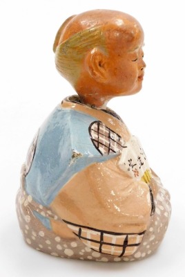 An early 20thC Japanese pottery nodding figure, modelled as a seated sage holding a fan, bears script, 15cm high, together with a Chinese brass and enamel napkin ring. (2) - 5