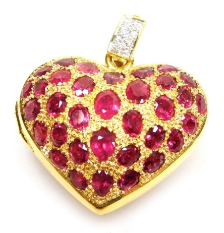 A heart shaped faceted ruby set pierced vinaigrette style locket, pierced back and faceted ruby set front hinged to open, set with thirty two generally oval shaped faceted rubies ranging from 4.8mm x 3.2mm to 2.1mm x 1.5mm approx, millegrain set in precio