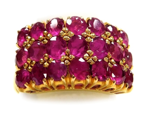 A multi row ruby set dress ring, three rows of seven round faceted stones of 1.6mm diameter average, claw set in precious yellow metal, size O, 5.1g all in, all stones have inclusions.
