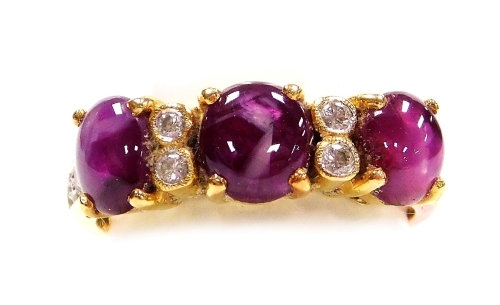 A cabachon ruby and diamond set in line dress ring, three dark rubies of 4.6mm x 3.8mm average, interset with pairs of tiny diamonds, three to each shoulder, the whole in precious yellow metal, rubies are heavily included, size K, 4.6g all in.