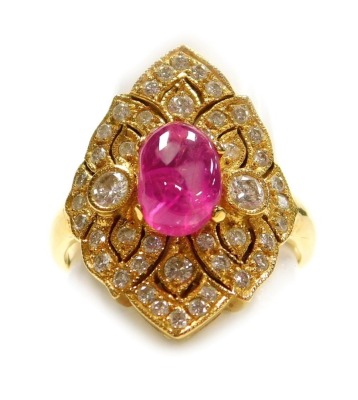 A cabachon ruby and diamond lozenge shaped dress ring, a central ruby of 8.1mm x 5.4mm, surrounded by tiny diamonds in a pierced precious yellow metal mount, forty four approx in total, size L, 5.6g all in, ruby is heavily included.