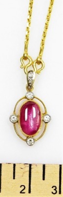 A cabachon ruby set pendant on chain, with diamond accents to the cardinal points with a tiny diamond set suspension loop, the cabachon ruby of 11.1mm x 6.7mm has rutile and other inclusions, all set in precious yellow metal, chain 36cm long, 10.4g all in - 2