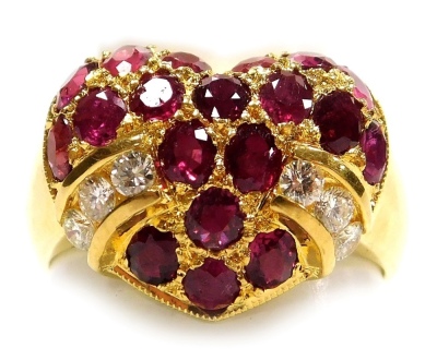 A heart shaped ruby and diamond set ring, the head set with nineteen oval faceted stones with six tiny diamonds to the sides, rubies average 2mm x 1mm, all set in precious yellow metal, 6g all in, size N.