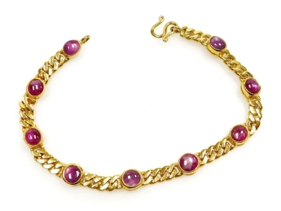 A cabachon ruby set bracelet, nine round rubies of 4mm diameter average, in rub over setting to curb link chain, 16cm long, (very small), 12.2g all in.