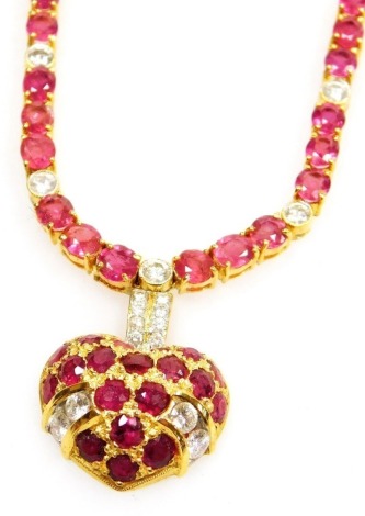 A heart shaped pendant on stone set chain, the pierced pendant set with oval faceted rubies, tiny diamond set suspension loop to ruby and diamond set necklace, each ruby average 1.8mm, each diamond average 2mm, all set in precious yellow metal, 38cm long 