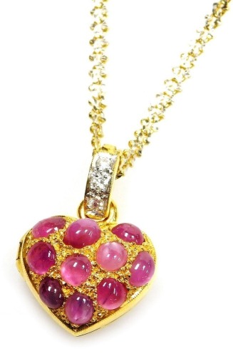 A heart shaped cabachon ruby set pendant locket, set with ten cabachon rubies of 3.8mm average, to a tiny diamond set suspension loop to a bi-colour precious metal chain, 38cm lng, 12.2g all in.